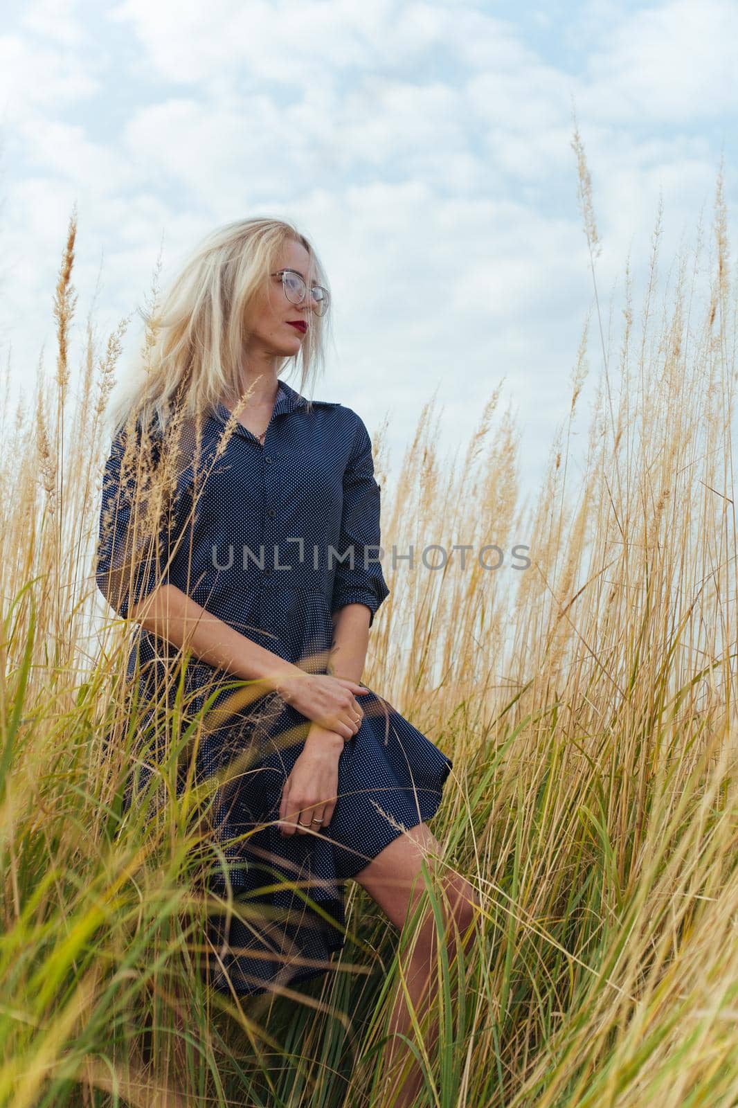 Beautiful girl villager posing in a dress in the field