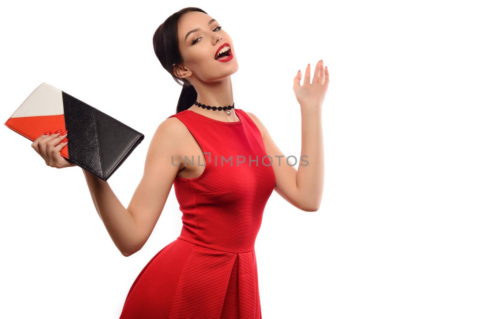 Beautiful girl in red dress with colorful clutch enjoys sale isolated on white background.