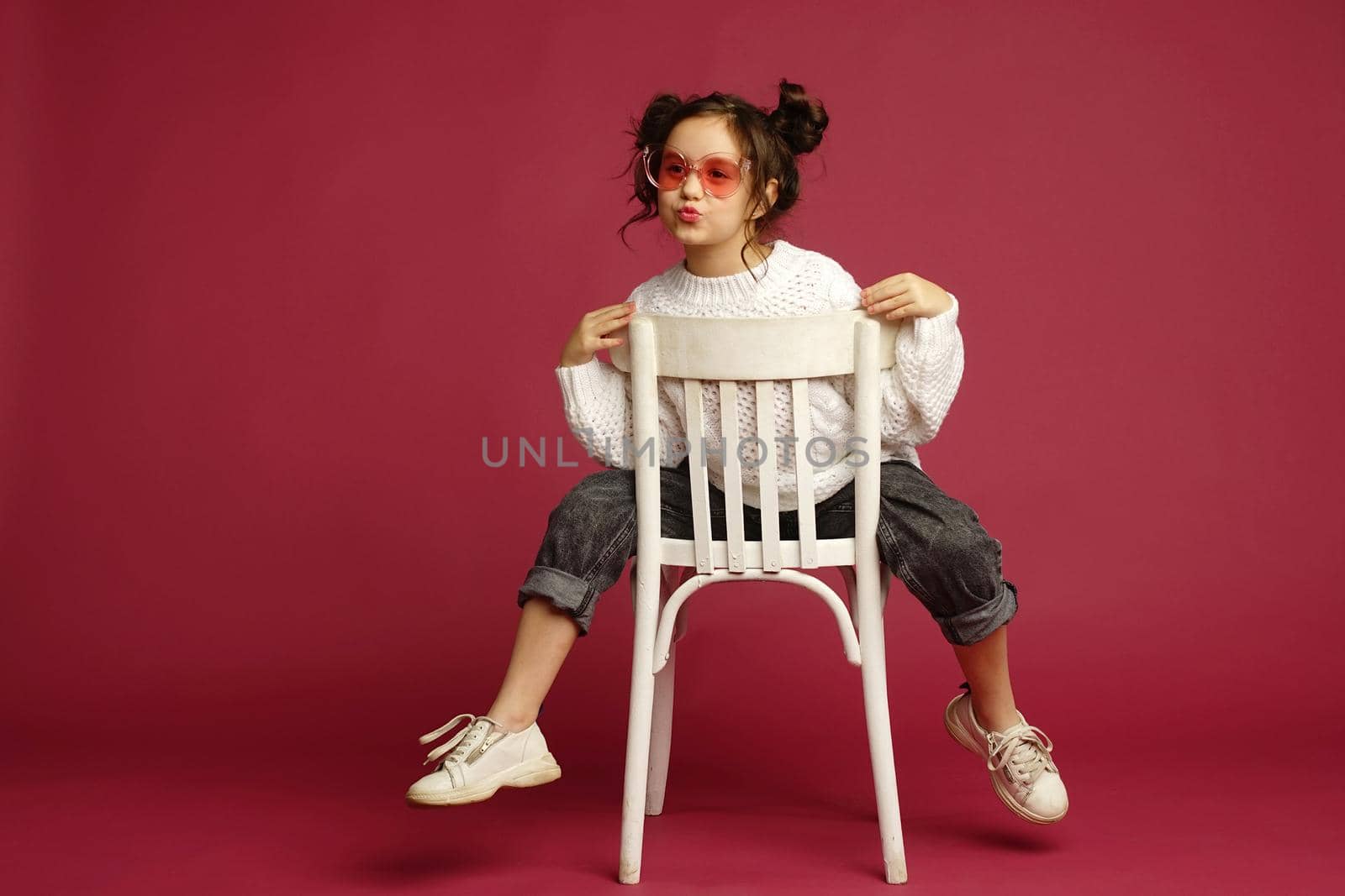 Photo of smiling little girl child isolated over pink background. Looking camera.