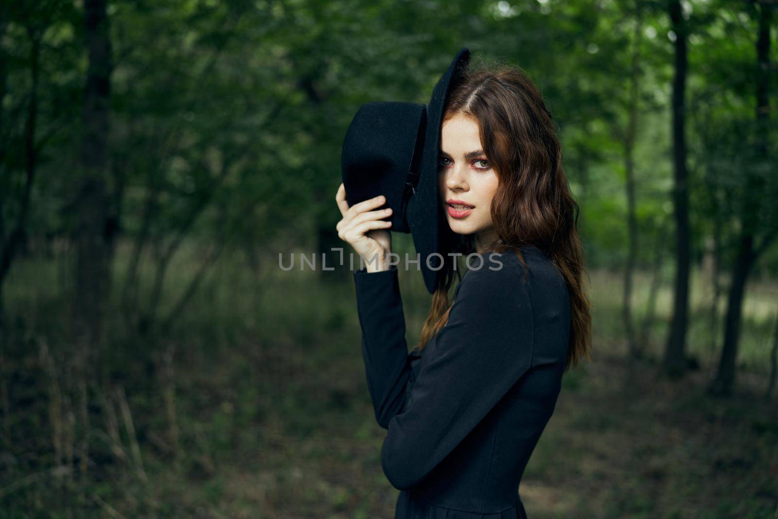 woman in the forest in a black hat gothic style Witch costume by Vichizh