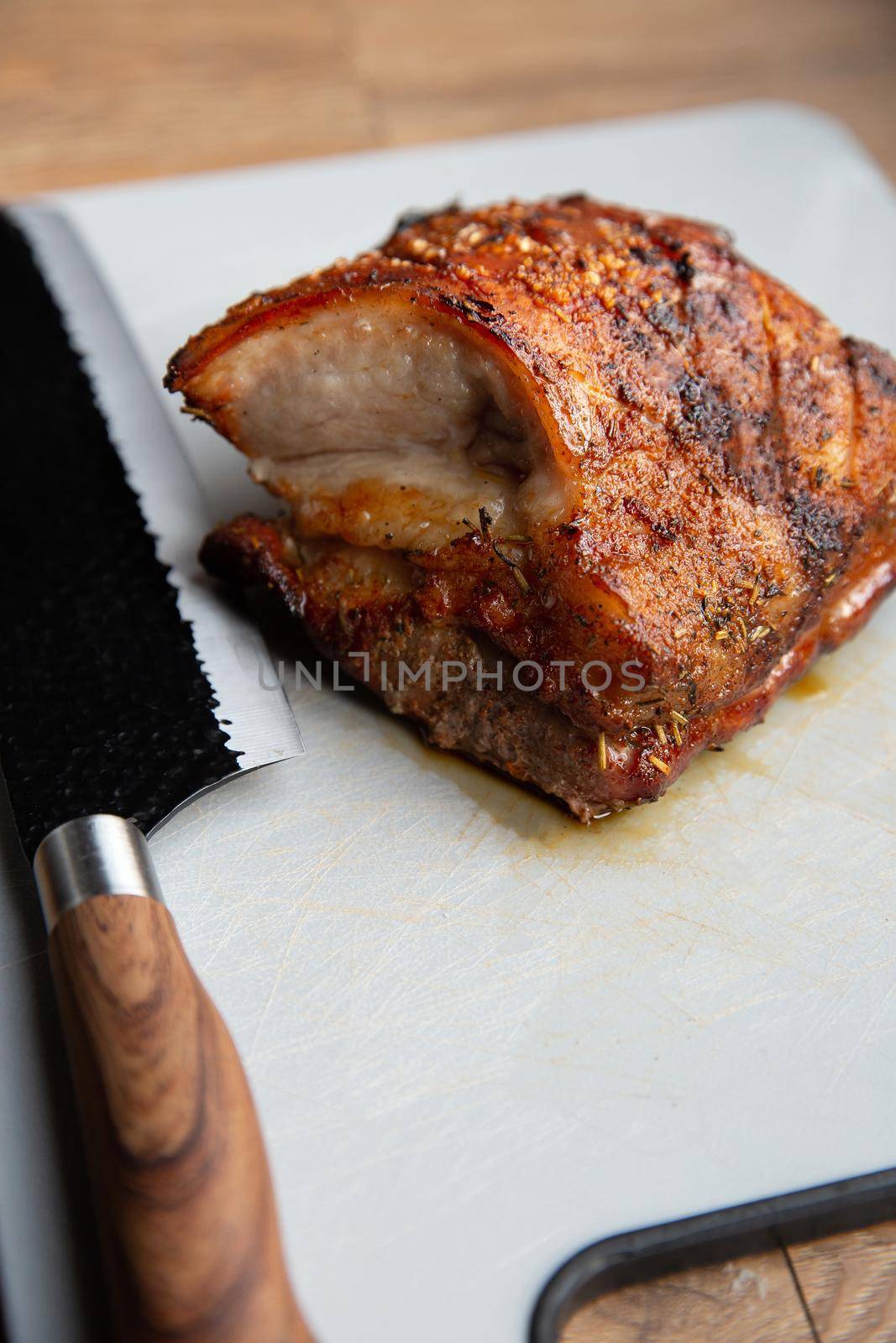 Grilled marinated Pork Belly barbecue with cutting knife and cutting board, closeup