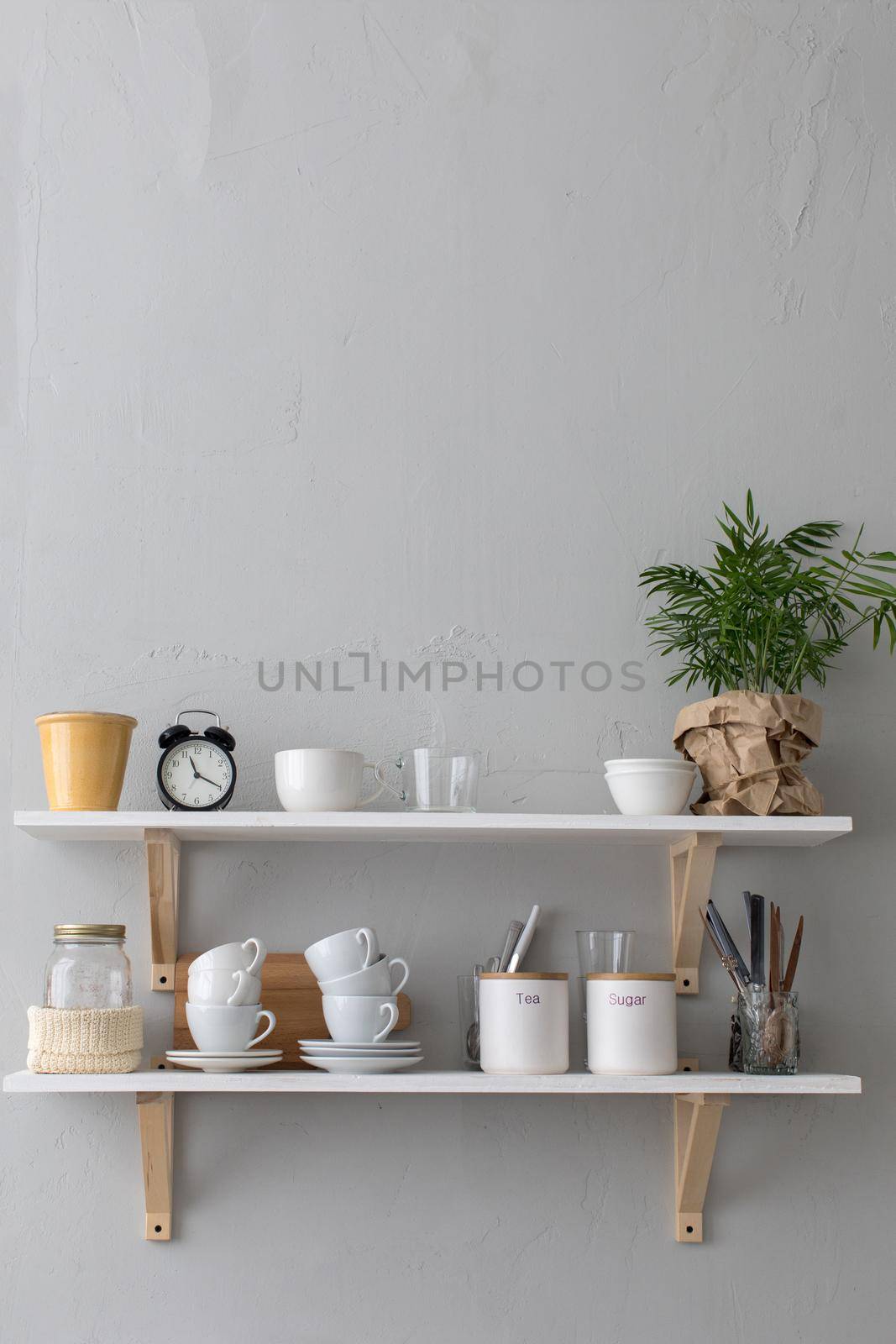 Close-up shelf with cups and different utensils.