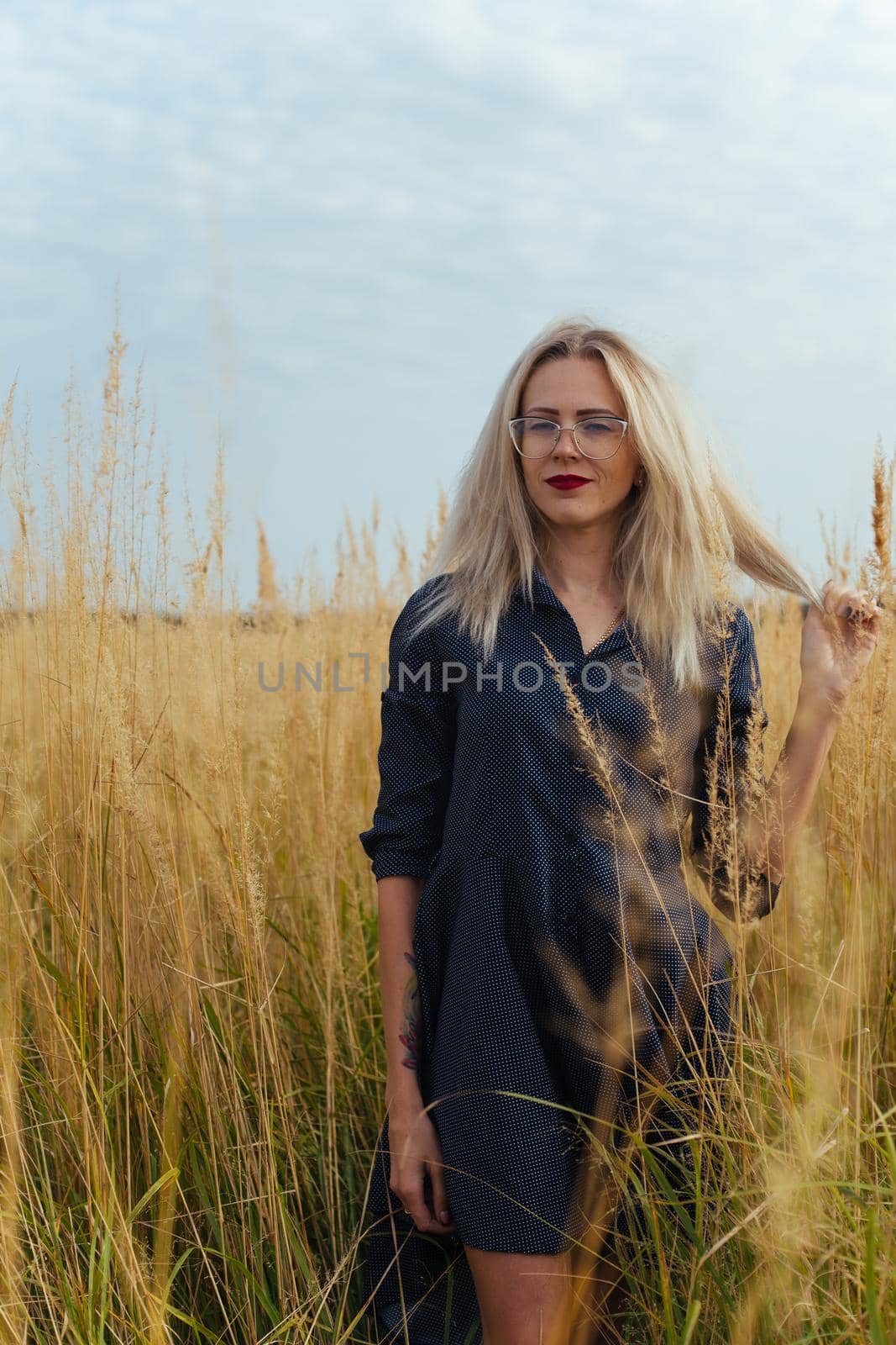 Beautiful girl villager posing in a dress in the field