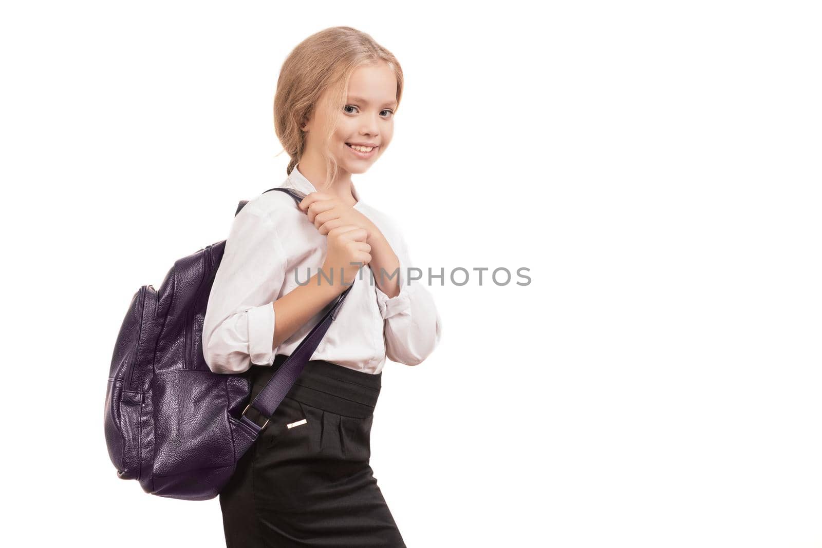 Young smiling happy school girl child with backpack in uniform isolated on a white background with copyspase