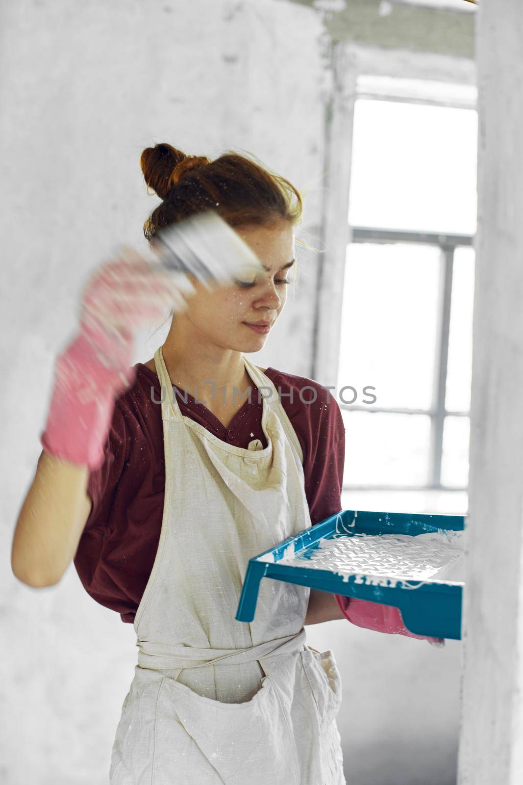 woman painter In white apron home renovation interior. High quality photo