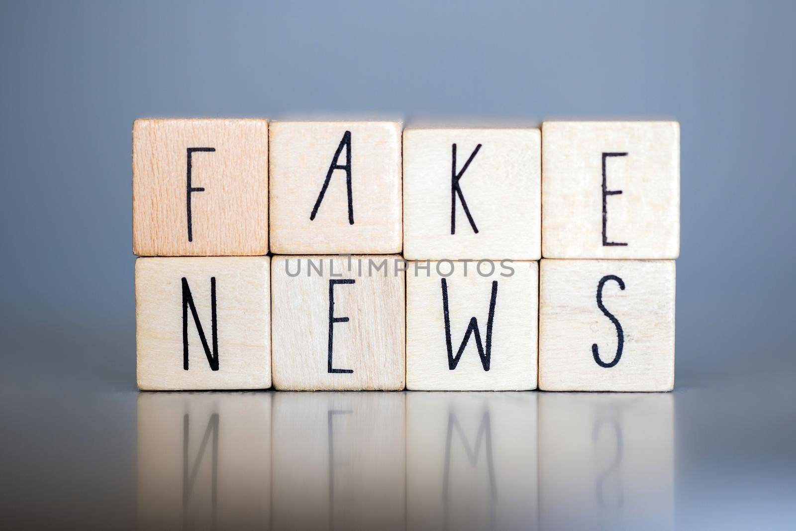 Wooden cubess with the words Fake News on grey background, Fake News concept social media close-up