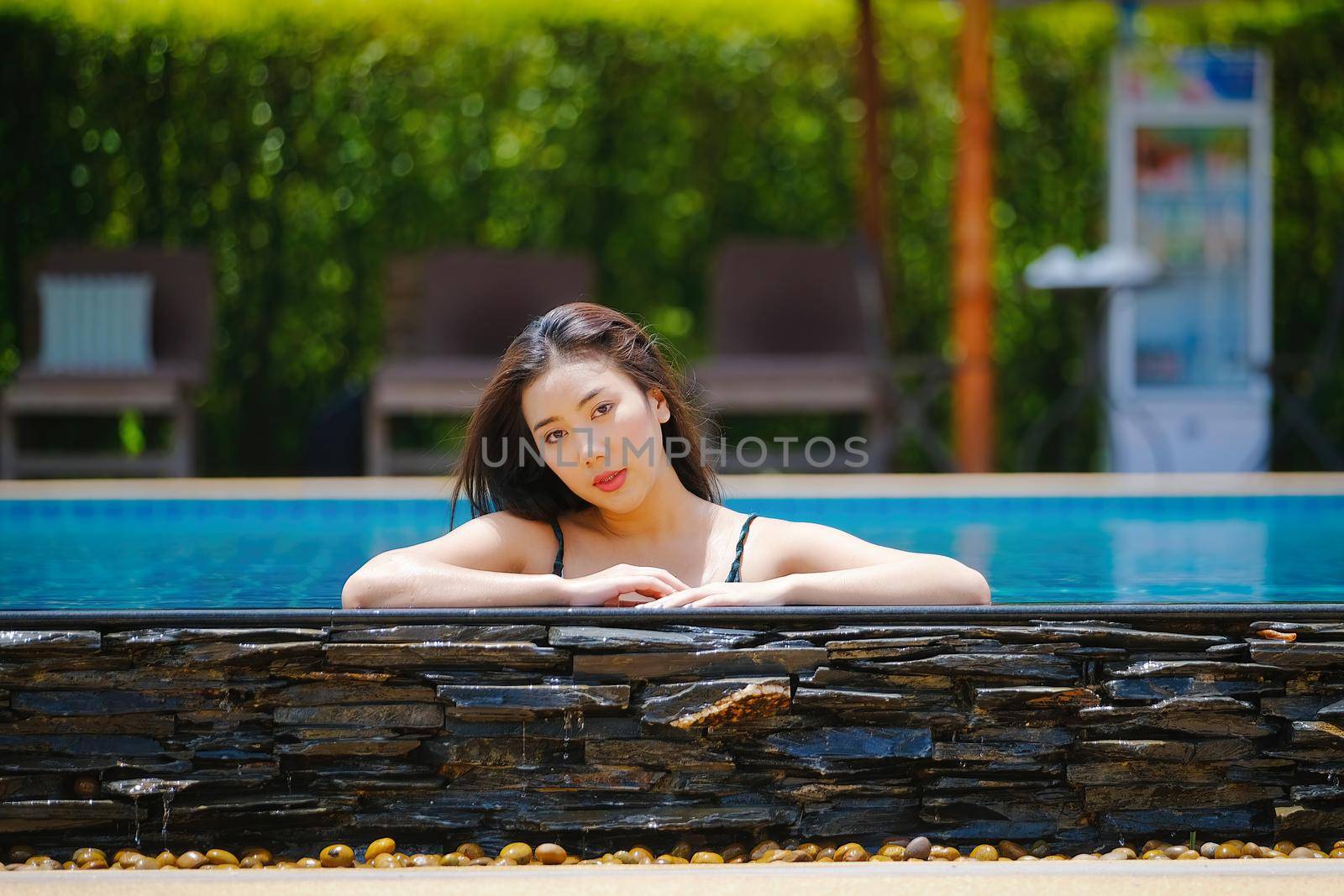 Beautiful southeast asia woman in pool relaxing. by Manastrong