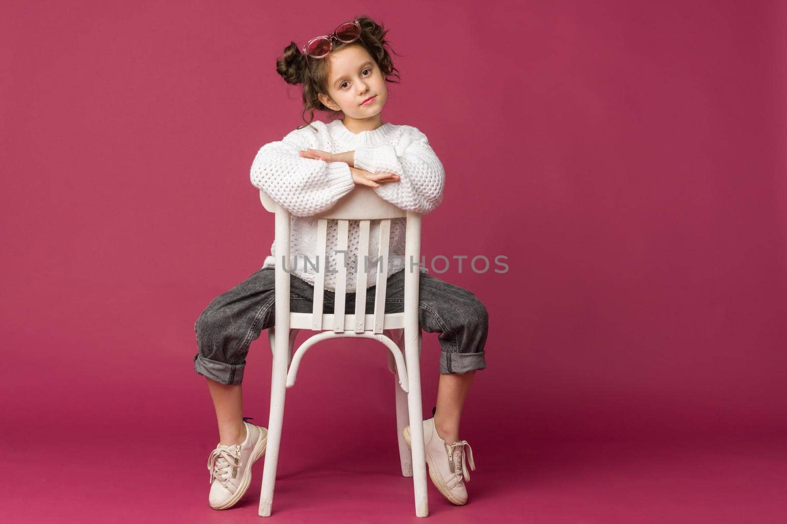 Photo of smiling little girl child isolated over pink background. Looking camera.