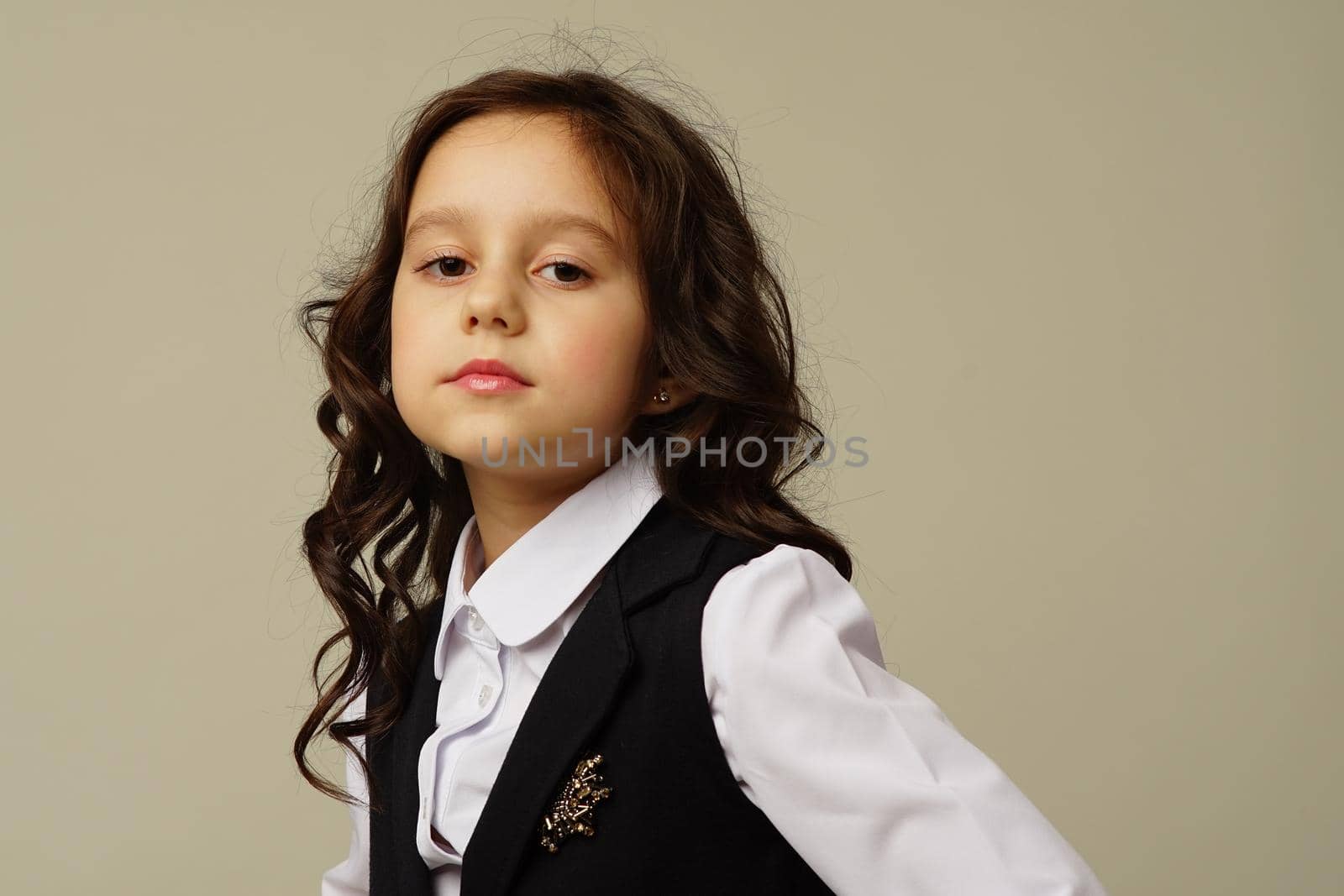 Photo of smiling little girl child isolated over grey background. Looking camera.