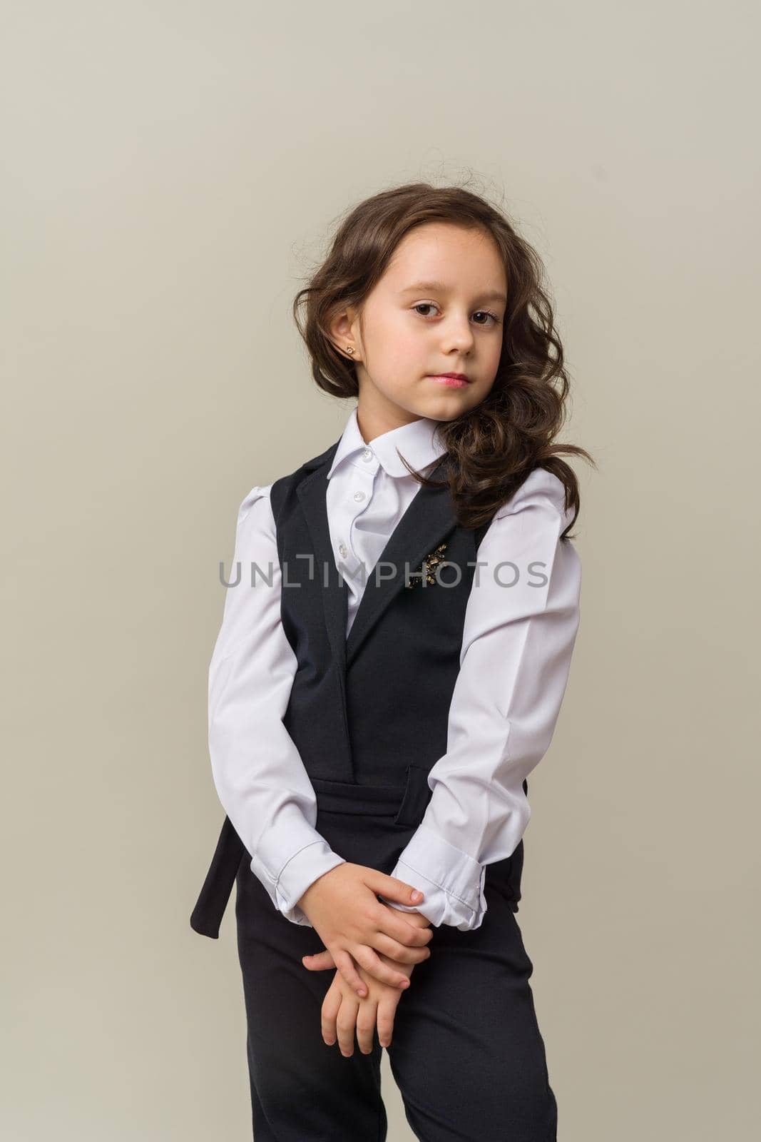 Photo of smiling little girl child isolated over grey background. Looking camera.