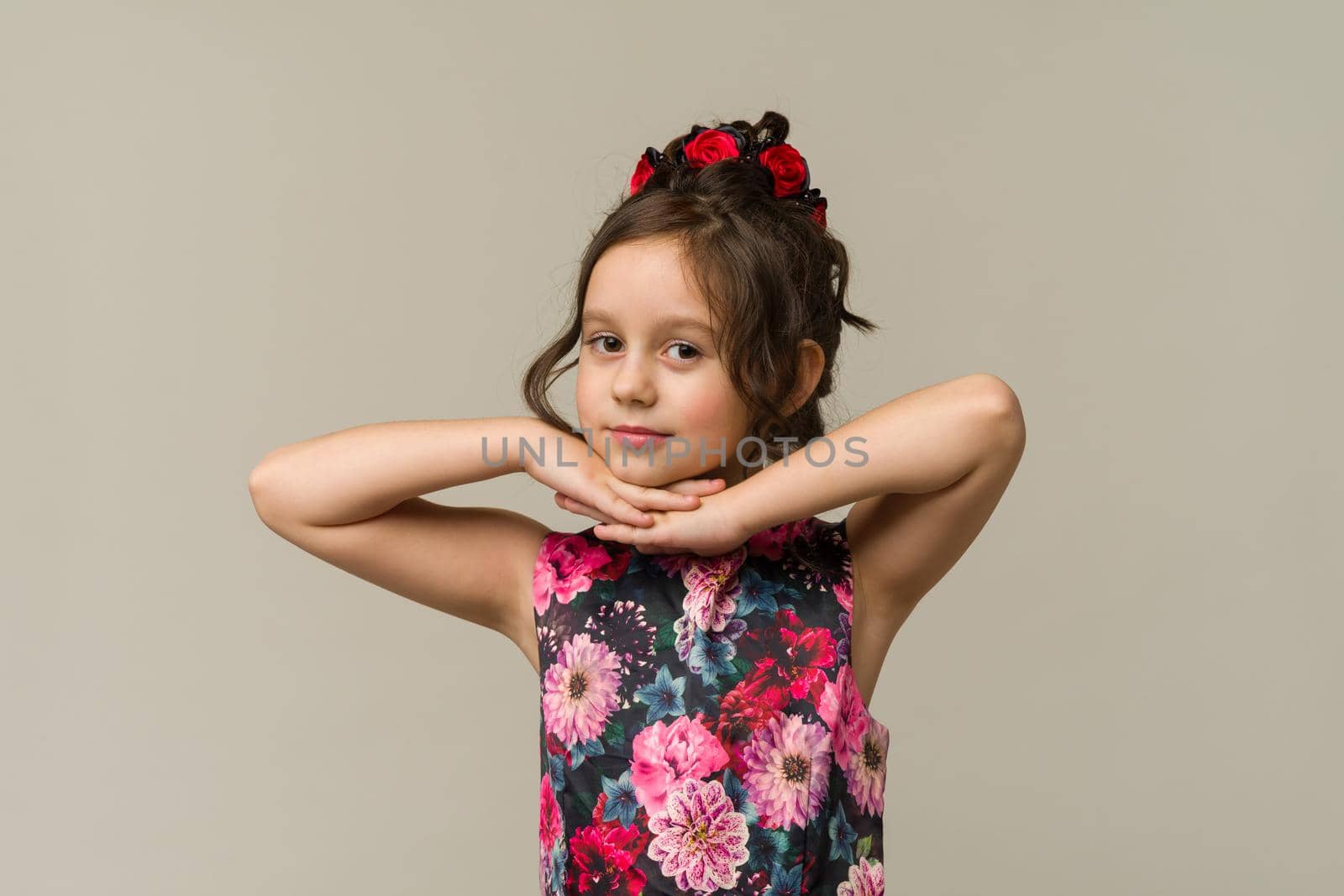 Photo of smiling little girl child isolated over grey background. Looking camera.