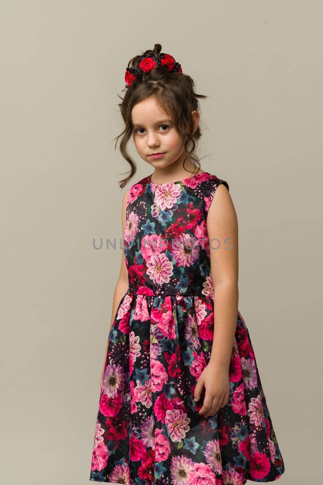 Photo of smiling little girl child isolated over grey background. Looking camera.