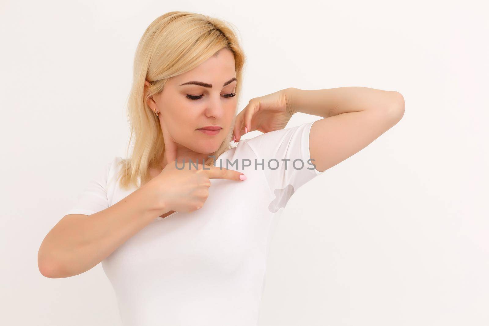 woman shows a spot on her white t-shirt