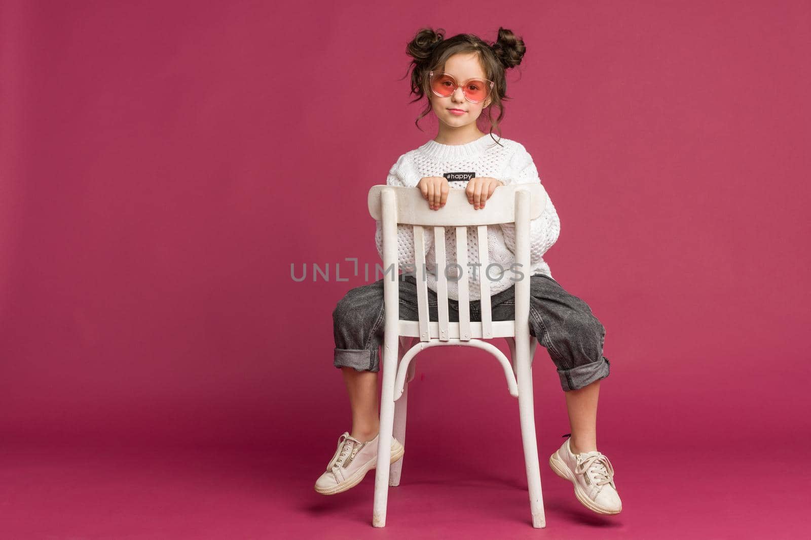 Photo of smiling little girl child isolated over pink background. Looking camera.