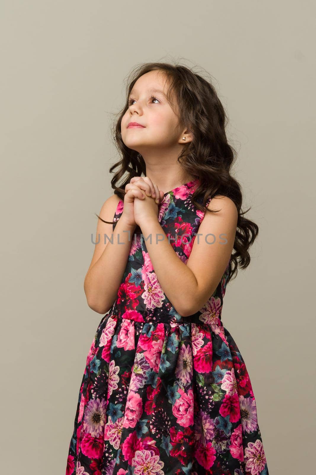 Photo of smiling little girl child isolated over grey background. Looking camera.