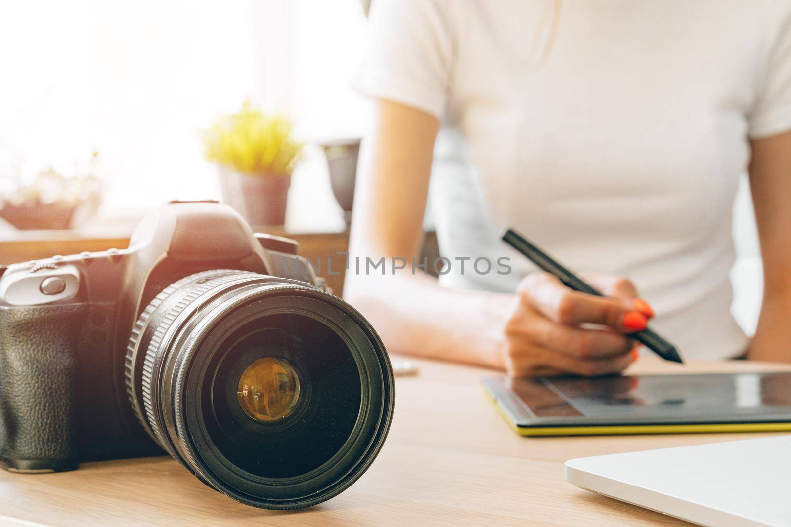 Young female photographer artist working at home office. Stay at home.