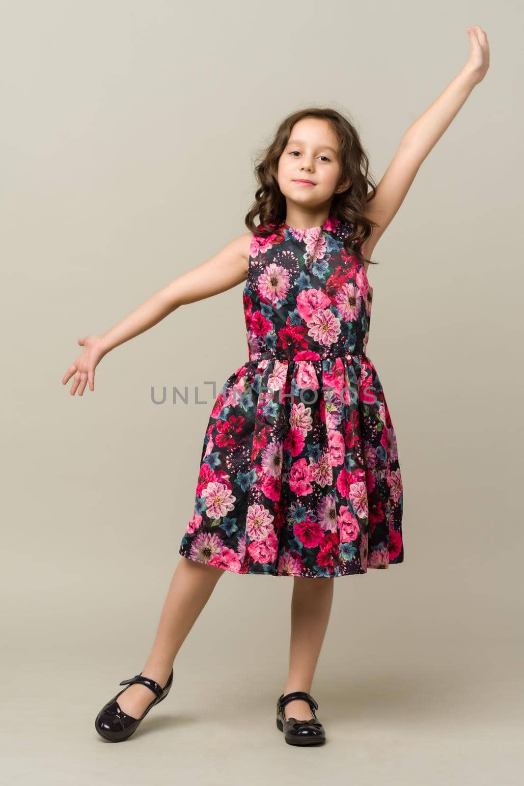 Photo of smiling little girl child isolated over grey background. Looking camera.