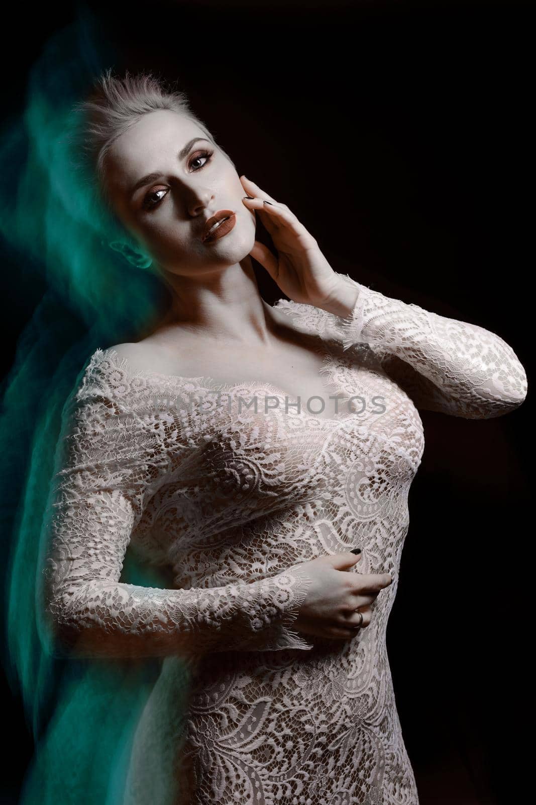 Beautiful girl in white lace negligee. A trace from a mixed light. The Snow Queen. Low key