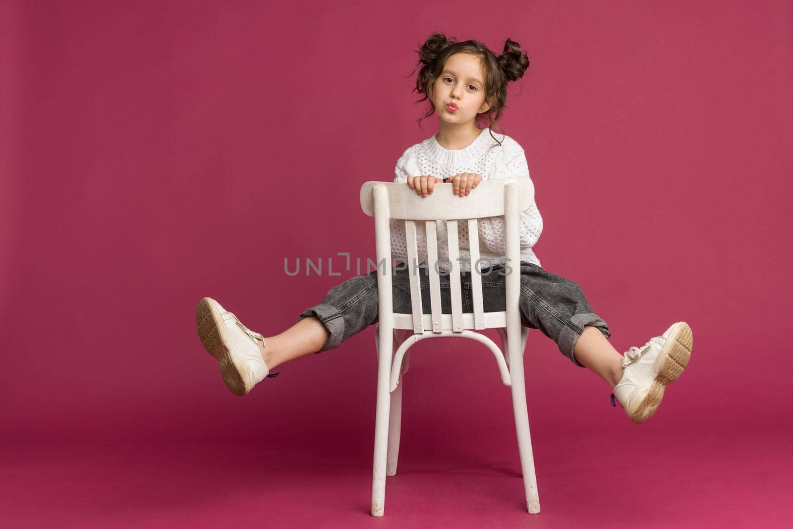 Photo of smiling little girl child isolated over pink background. Looking camera.