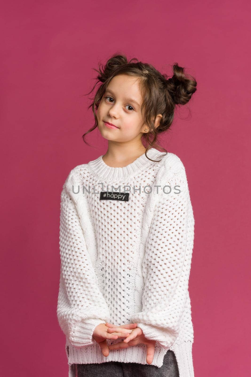 Photo of smiling little girl child isolated over pink background. Looking camera.