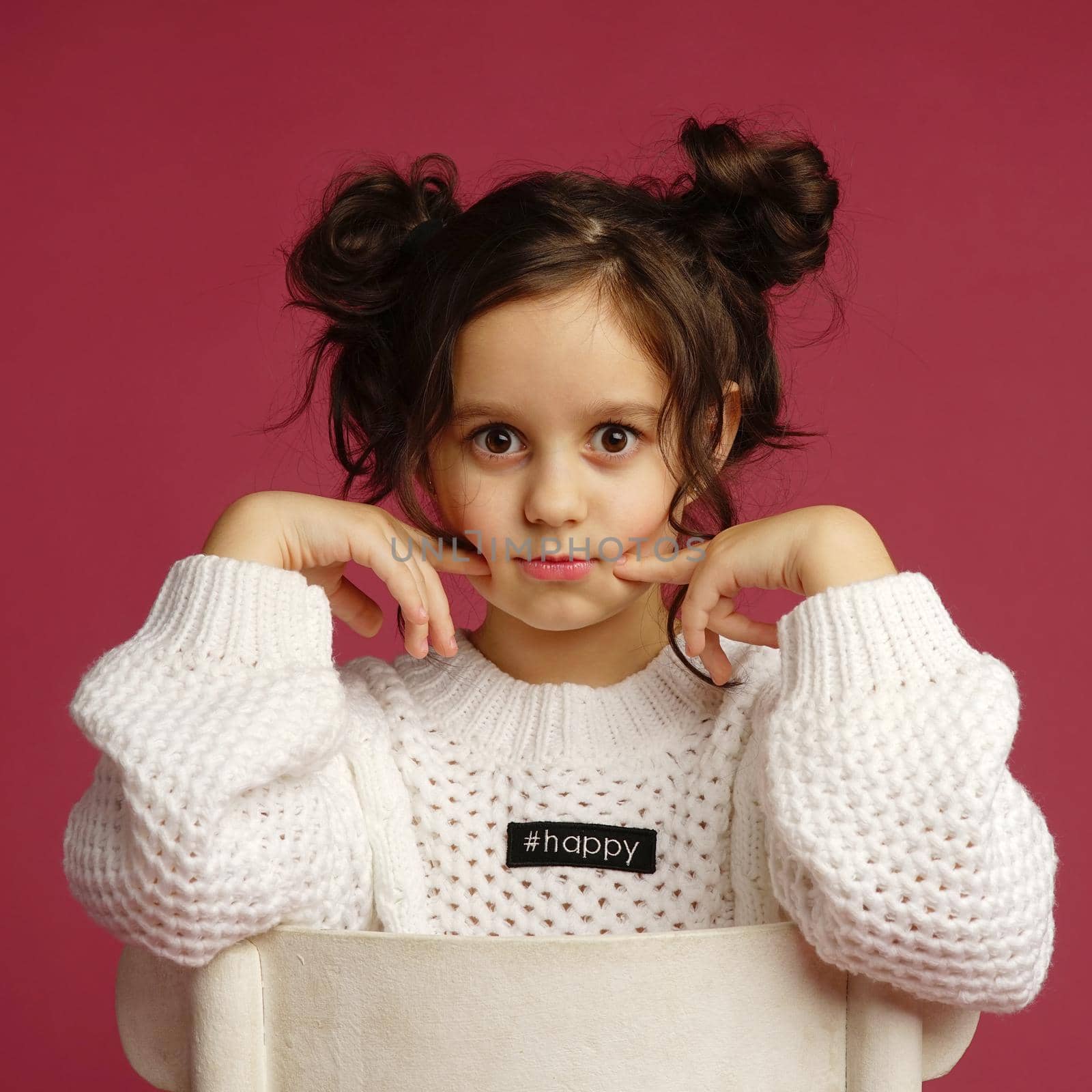 Photo of smiling little girl child isolated over pink background. Looking camera.