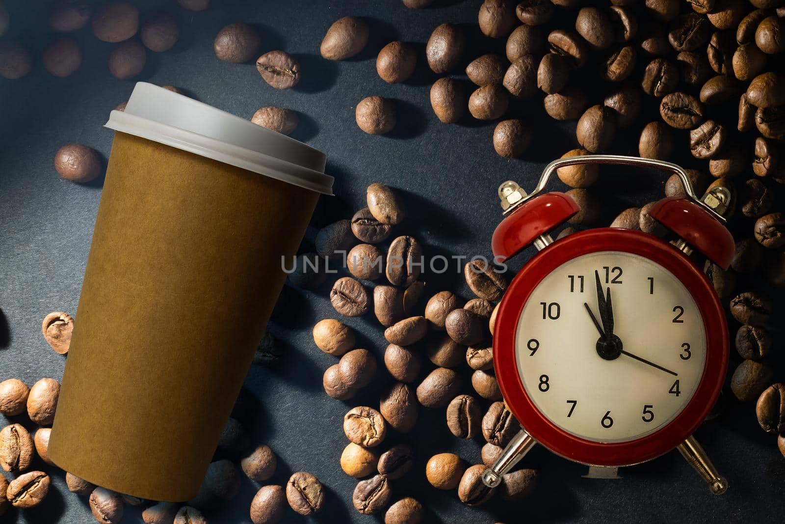 Photo of a paper coffee cup with a mixture of arabica and robusta beans in the background