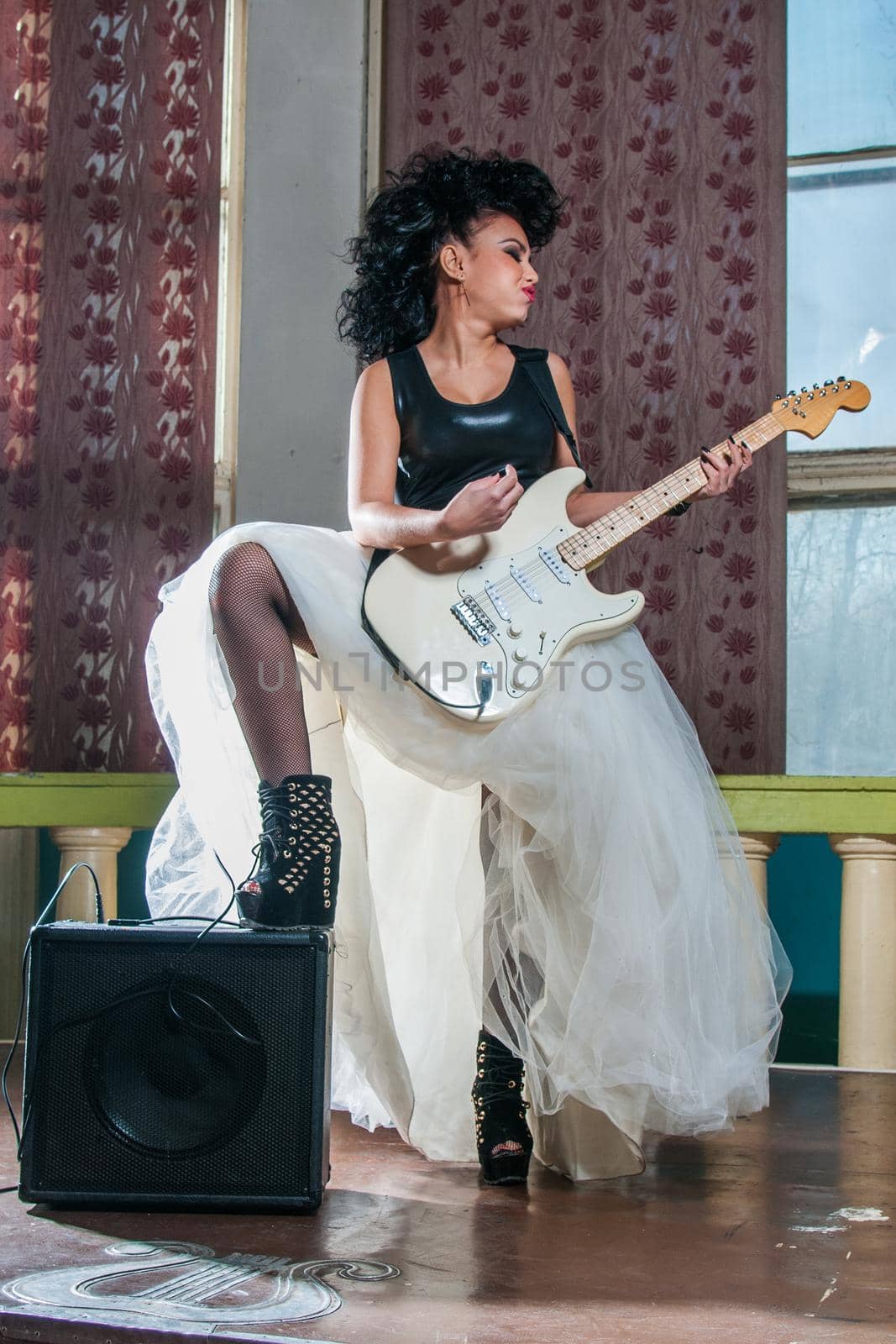 Photo of a female guitarist playing an electric guitar.
