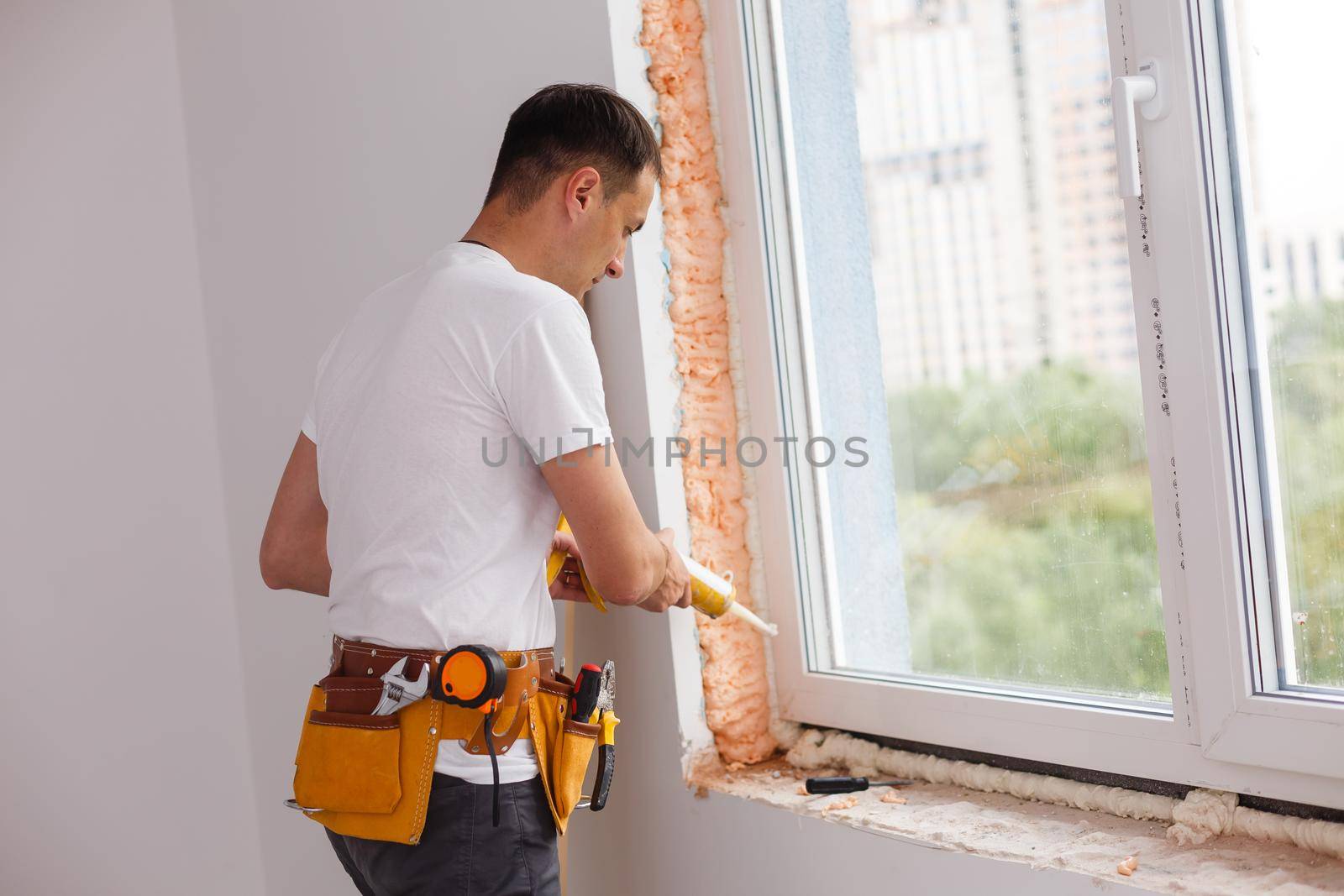 Man putting filling between window and wall in a new house