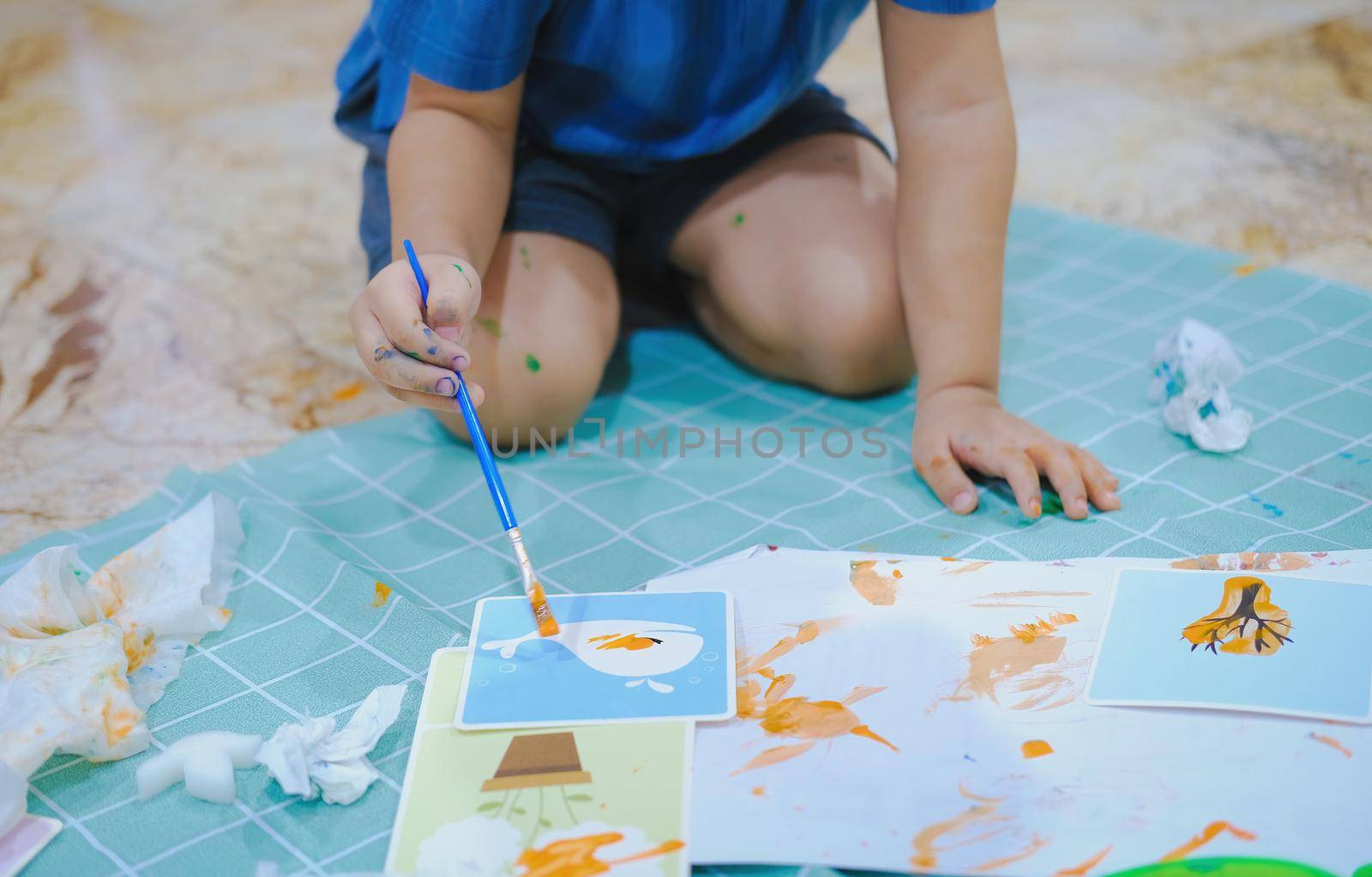 Children use paintbrushes to paint watercolors on paper to create their imagination and enhance their learning skills. by Manastrong