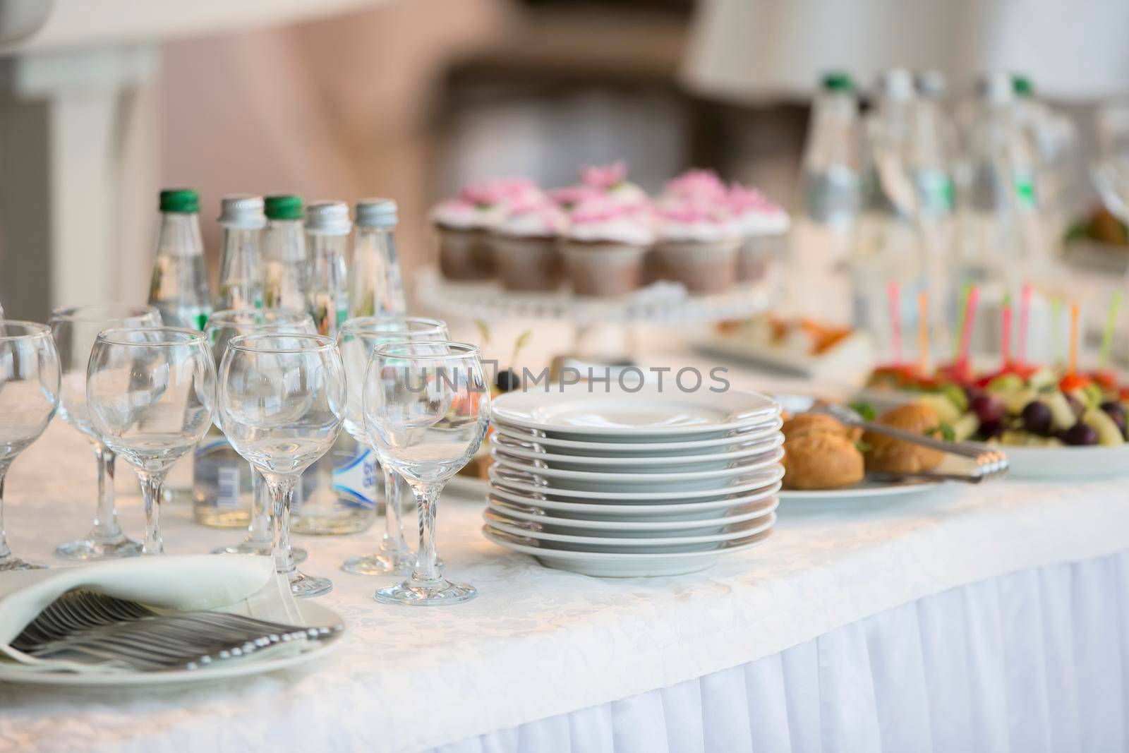 Buffet table with dishes and snacks.A stack of white plates on the table of the buffet table