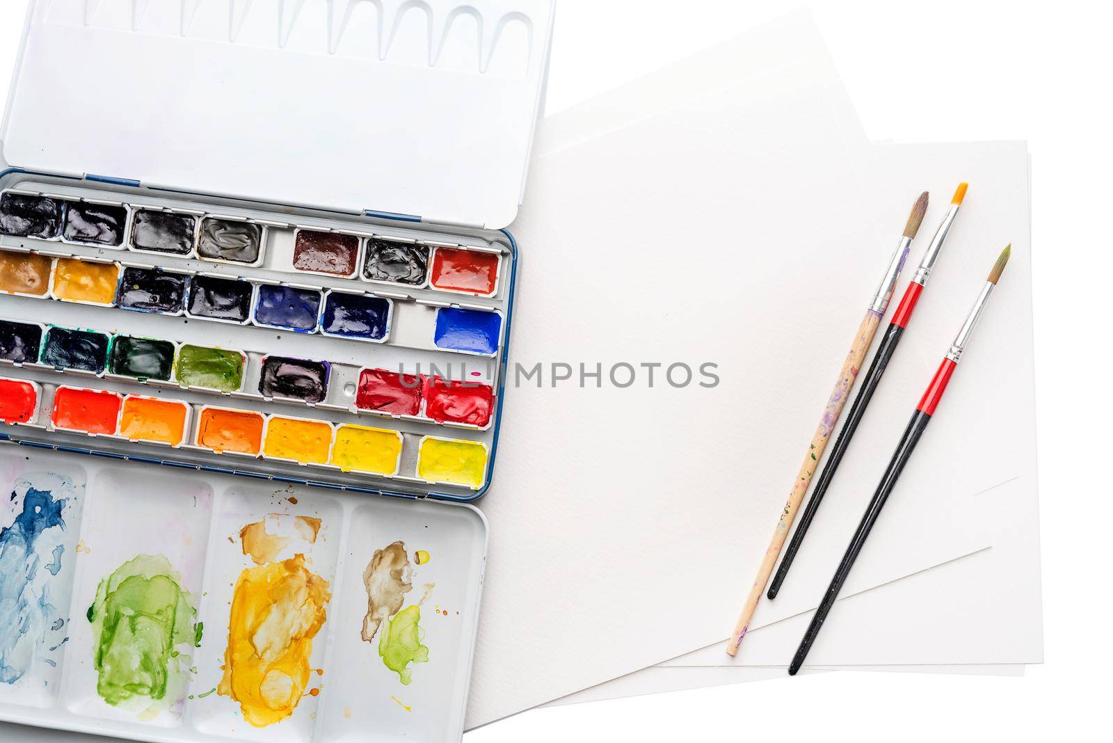 Colorful stained paintbox with various brushes, isolated on white background