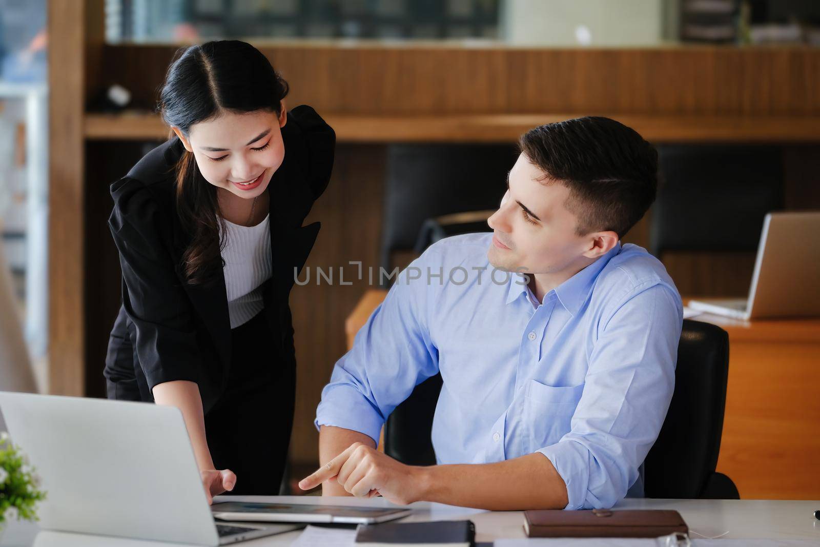 The male marketing manager expressed his satisfaction in selling the company's products. where team members show sales from their iPad screen