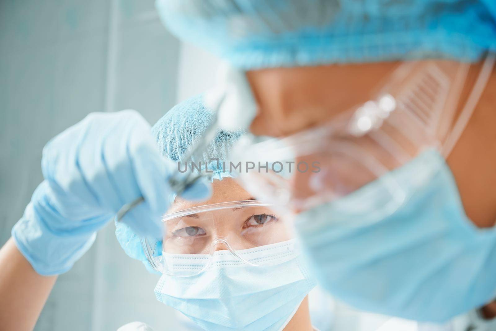 Surgical woman nurse rubs forehead of man surgeon on operation, focus on nurse