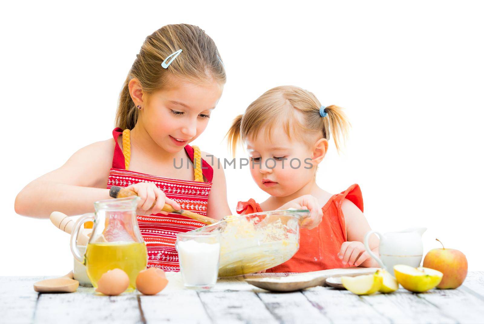 two cute little sisters baking on a white background