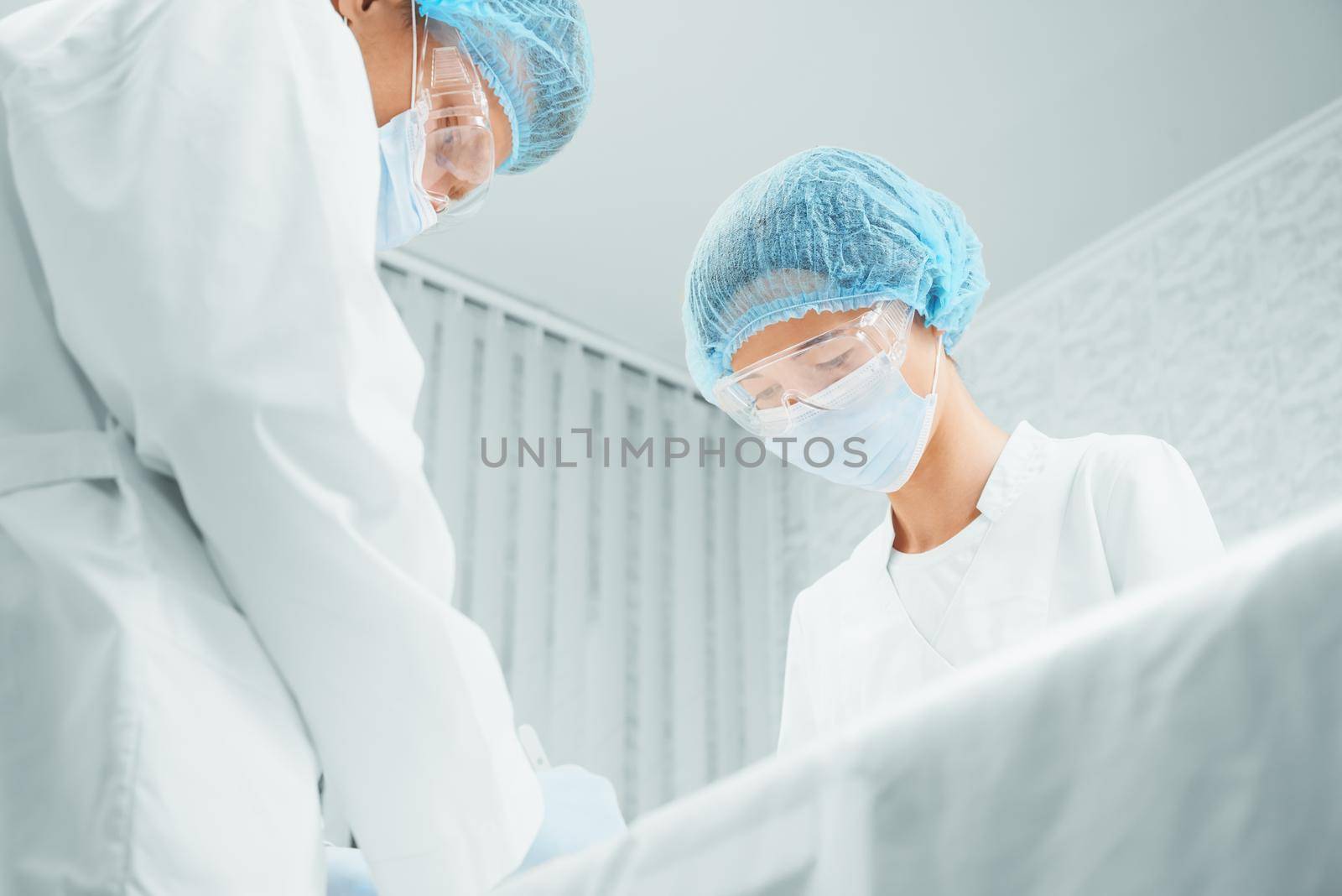 Male and female surgeons are working in operating room, teamwork