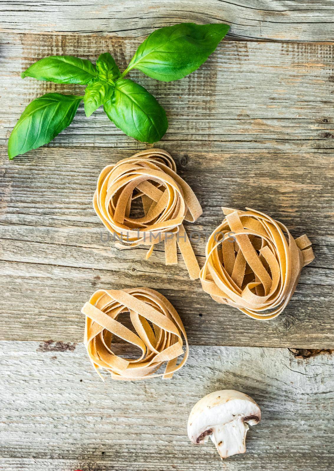 rolled fettuccine pasta nest on wooden background