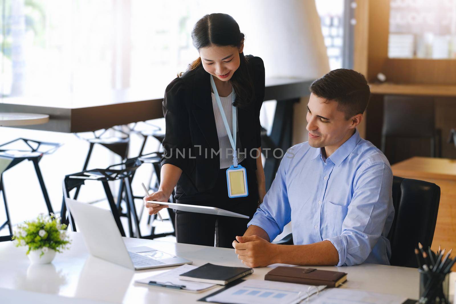 The male marketing manager expressed his satisfaction in selling the company's products. where team members show sales from their iPad screen