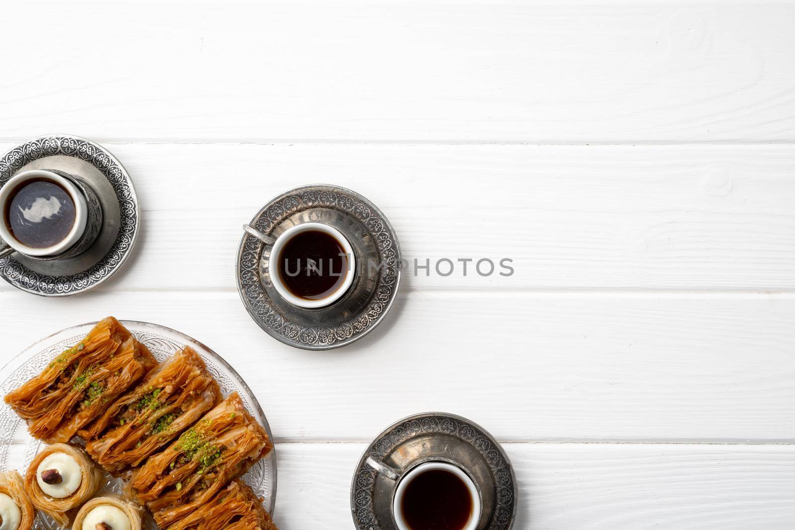 Top view of Turkish sweets and Turkish coffee on white wooden background, close up
