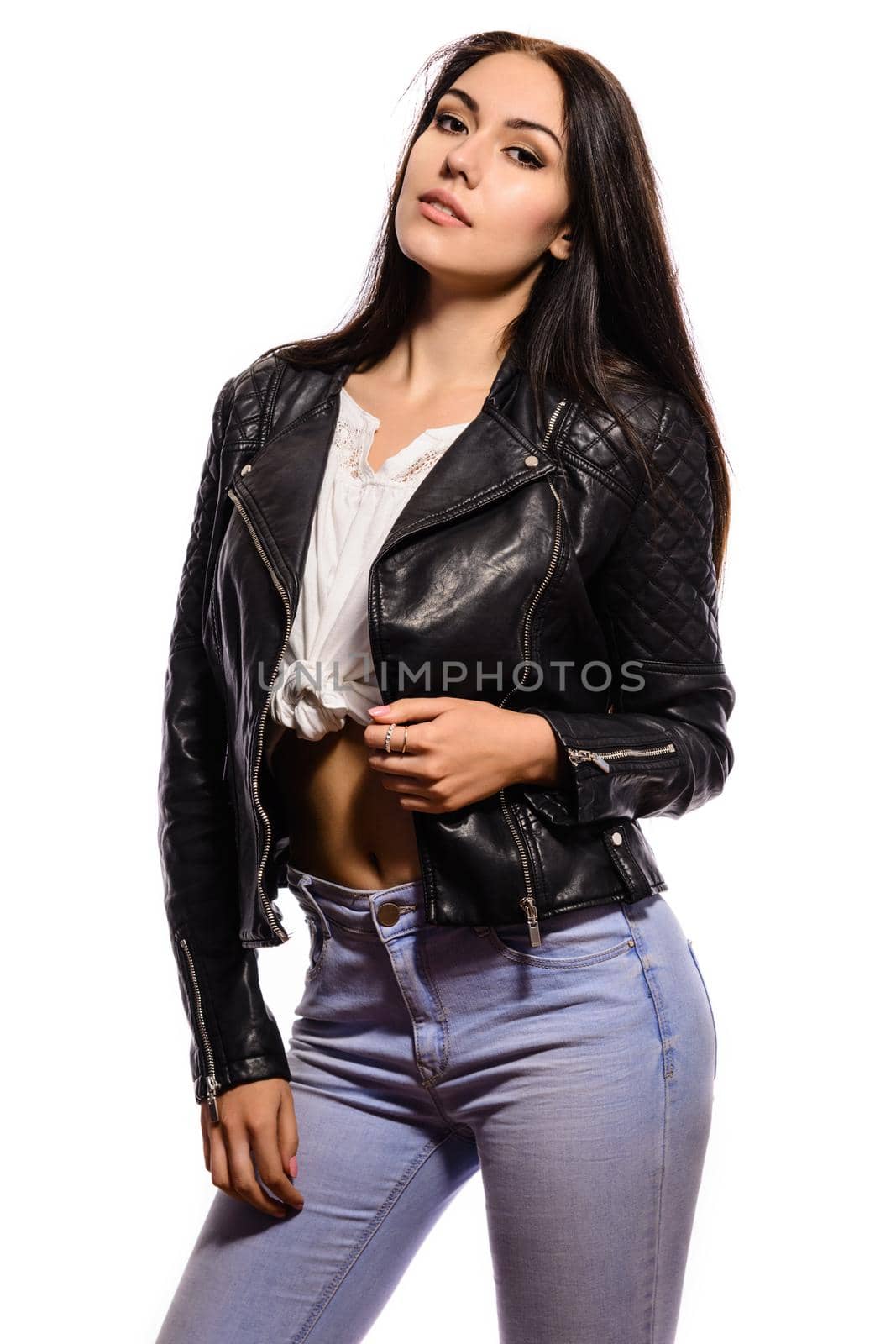 Glamorous young woman in black leather jacket and jeans on white background