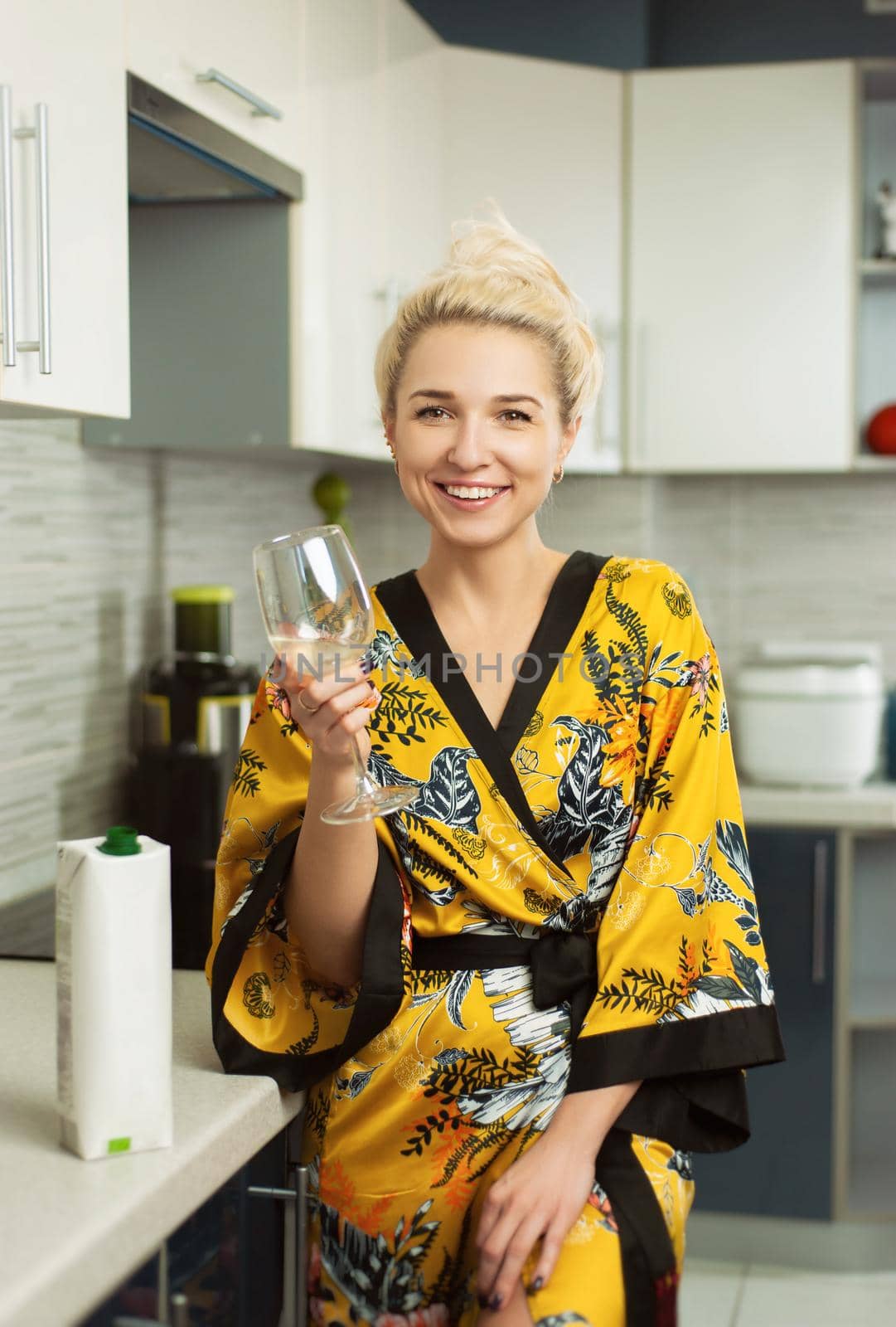 the Young clapboard in the kitchen with a pack of healthy natural juice drinks from a glass