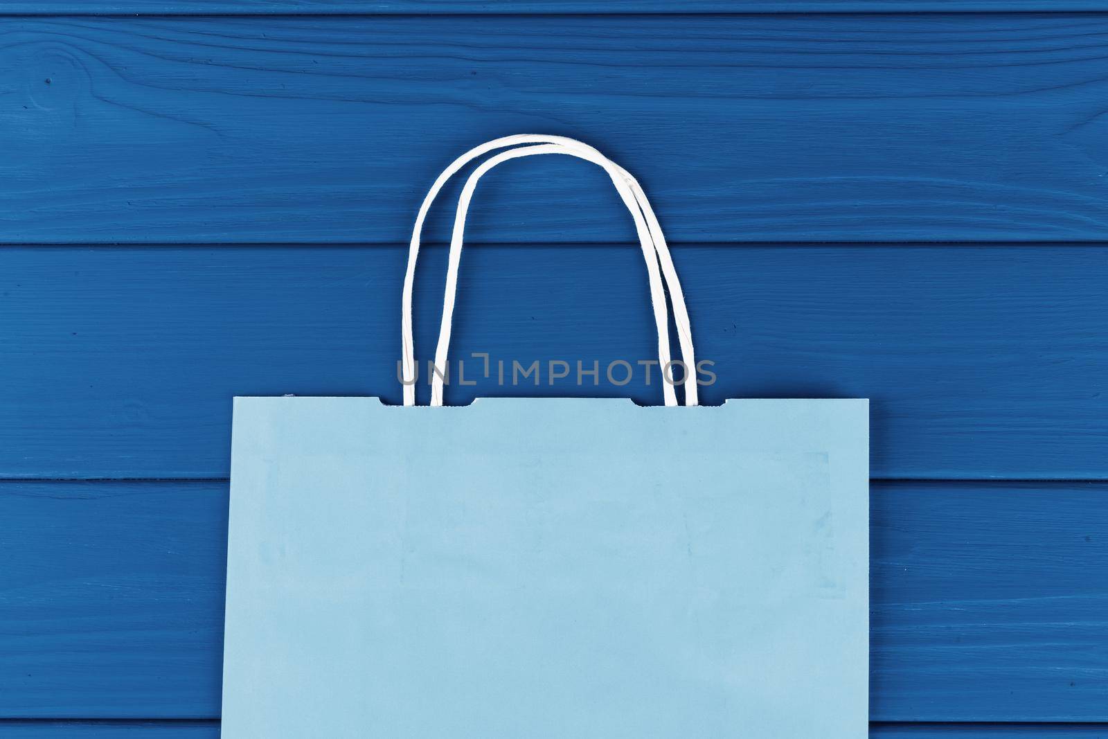 Blue shopping bag on blue background, top view. Close up.