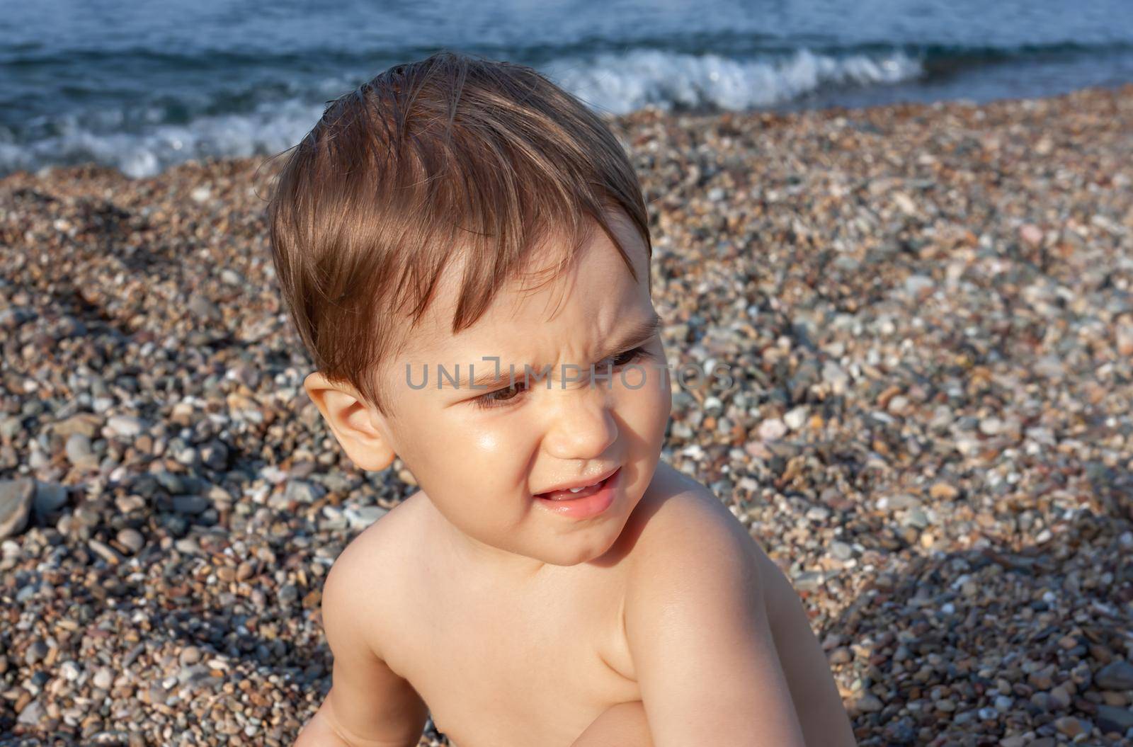 Healthy lifestyle. Little boy resting and having fun on a rocky beach on the Mediterranean coast