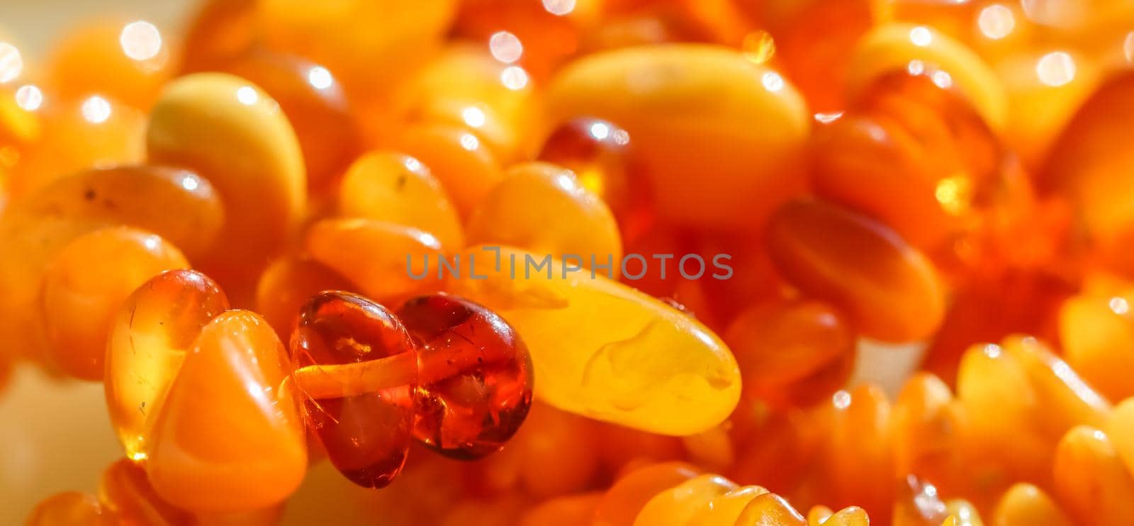 Sunny beads of fire amber. Natural gemstone background, jewelry concept