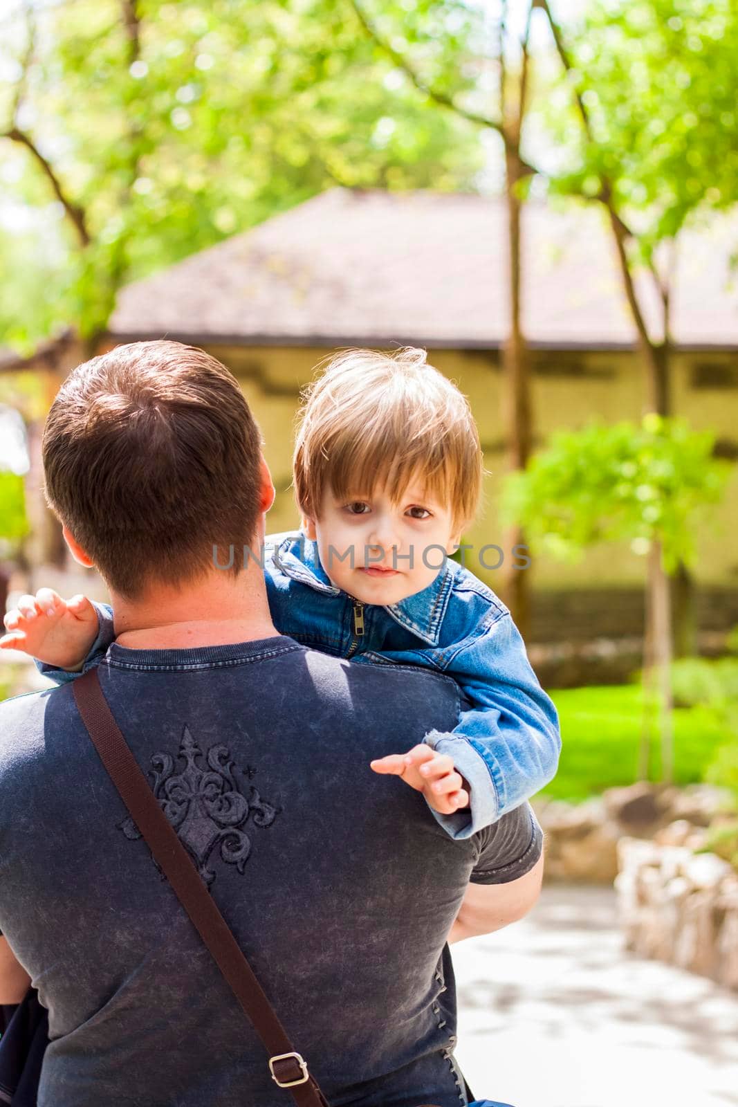 A male father spends time with his young son. Family walks in nature. The joy of being together.