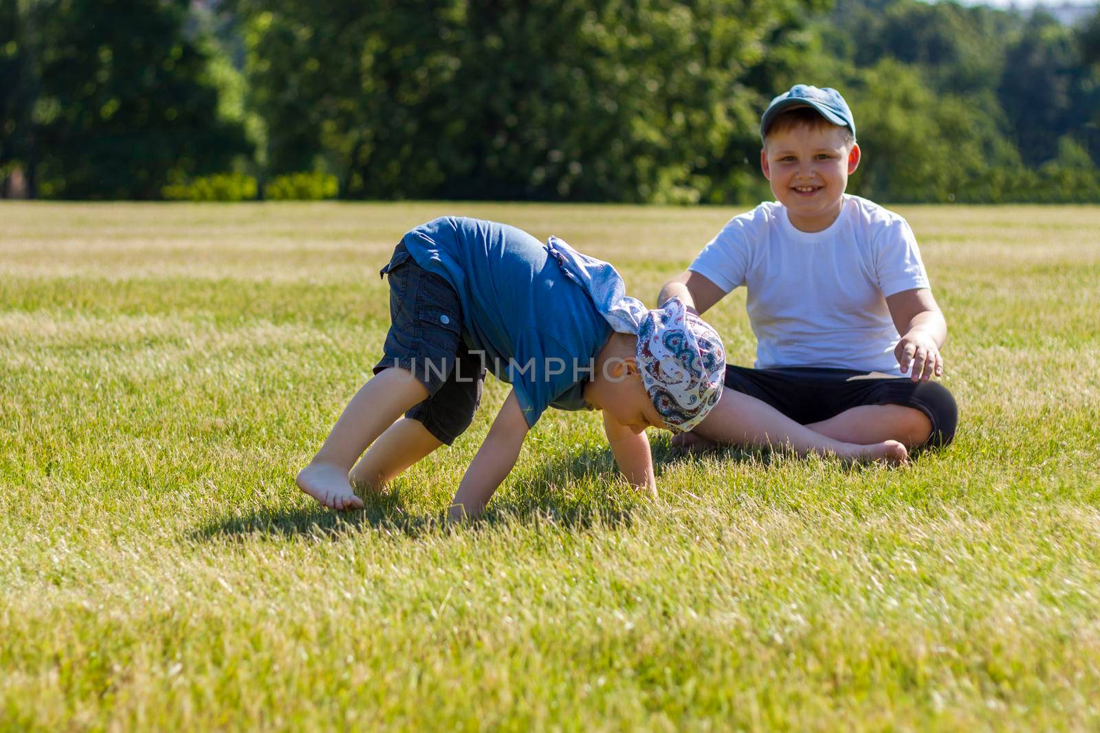 Cheerful children, two brothers, smile with joy. we are happy to walk and play on the lawn in warm sunny weather in the park. the emotions of children on the face. Happiness 