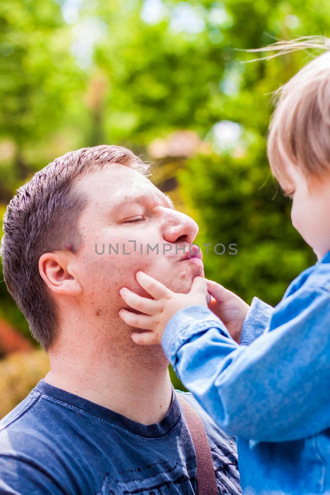 A male father spends time with his young son. Family walks in nature. The joy of being together.