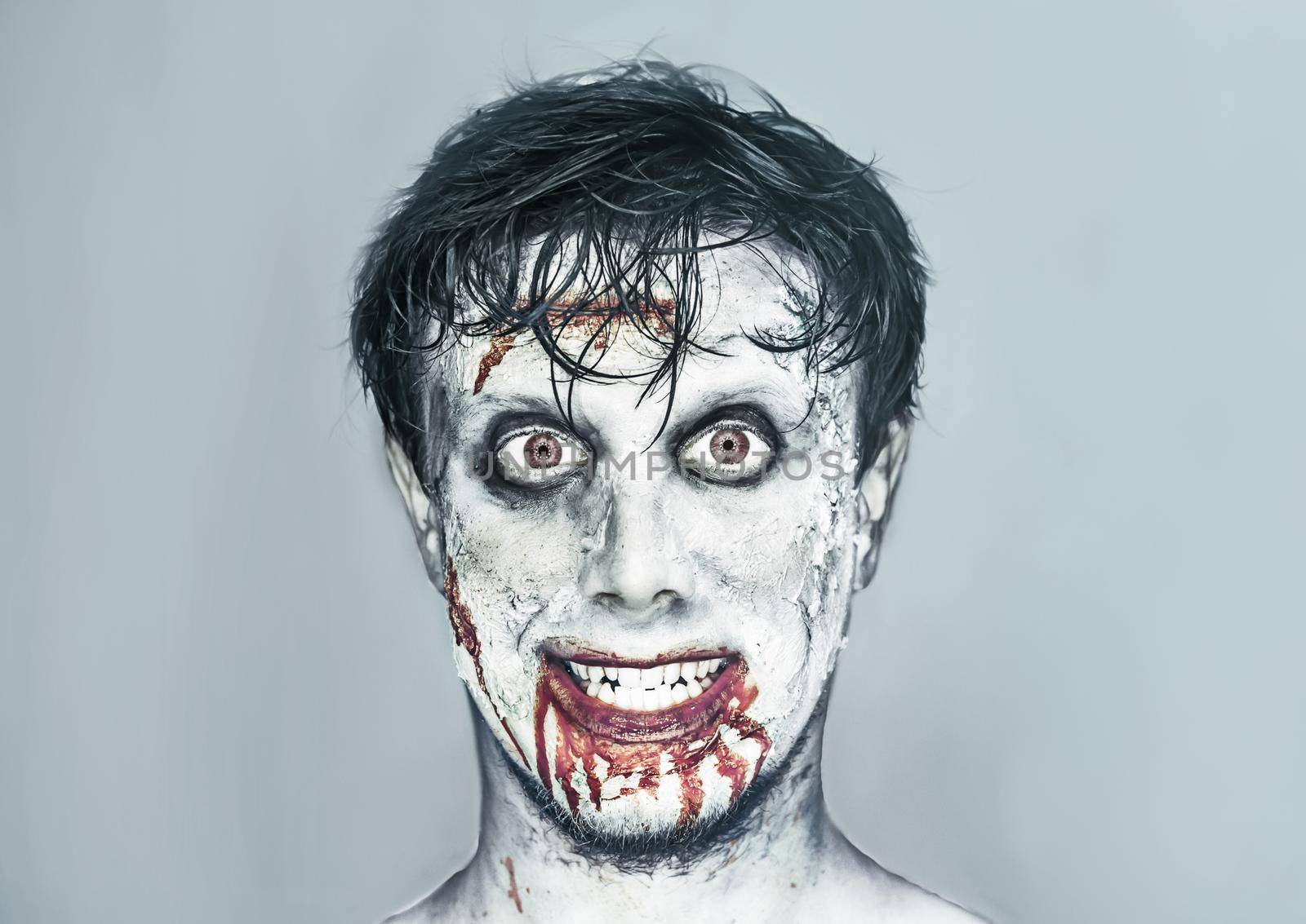 Portrait of happy man with zombie face art. Halloween or horror theme