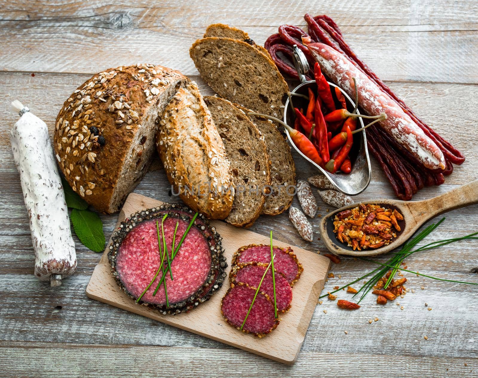 grey bread and different kind of salami isolated on wooden background
