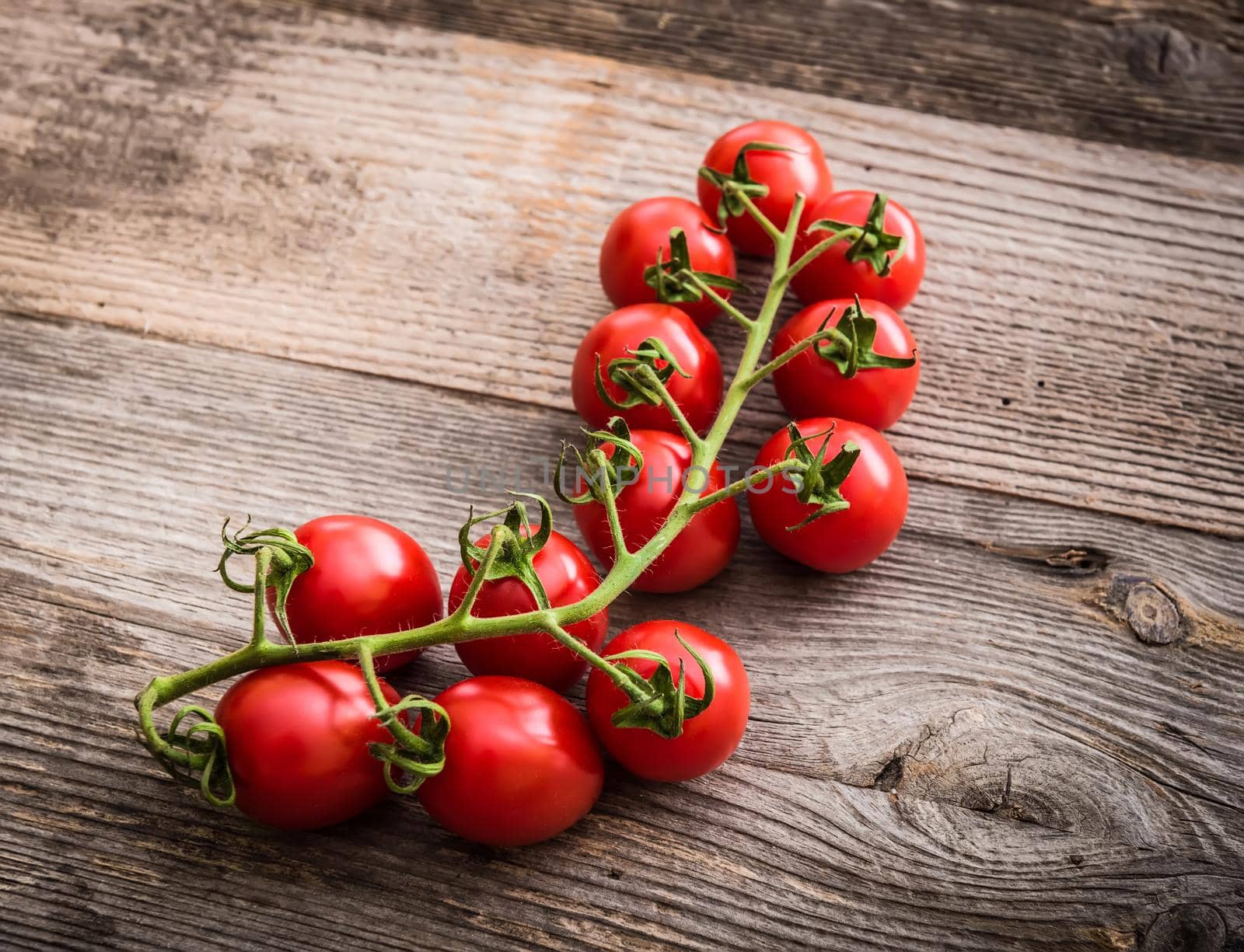 branch of cherry tomatoes on a wooden background