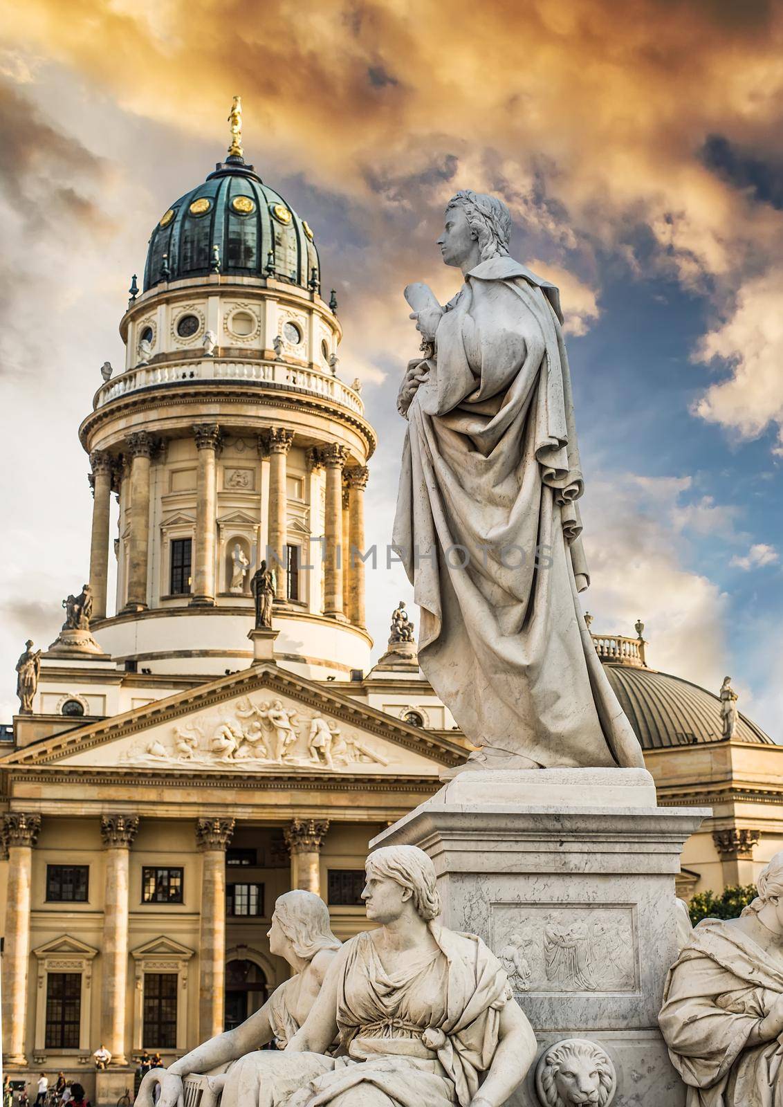 Beautiful squares in Berlin, the Gendarmenmarkt, marble statue of German poet Friedrich Schiller at sunset